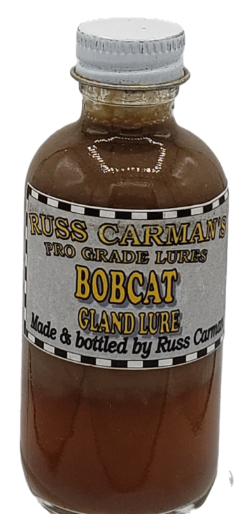 Small bottle labeled "Carman's Pro Grade Bobcat Gland Lure," with brown liquid, made and bottled by Russ Carman.