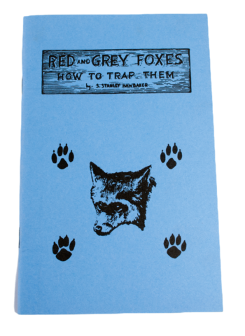 Blue booklet titled "S. Stanley Hawbaker - Red and Gray Foxes: How to Trap Them," featuring fox and paw prints illustration.