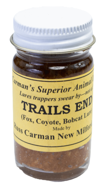 A small jar of Carman's Trails End Lure for trapping foxes, coyotes, and bobcats with a yellow label and silver lid.