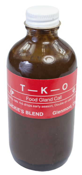 A brown glass bottle with a white cap, labeled "Blackie's T-K-O Lure," features Blackie's lure on a red background.